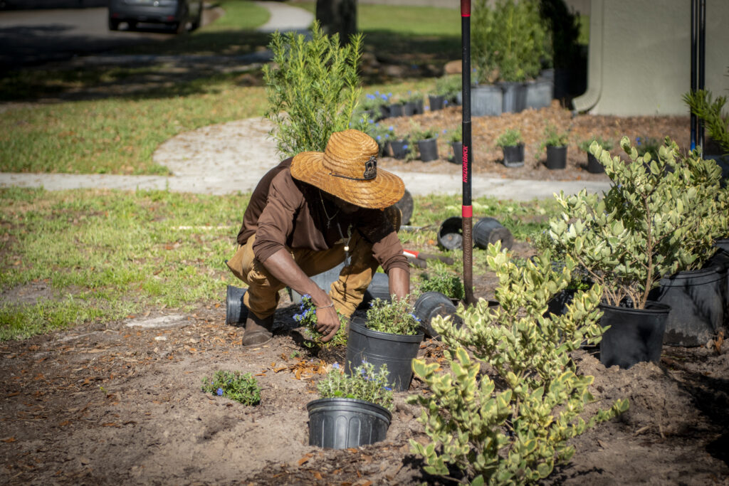 Copperhead property maintenance employee planting shrubs in mulch beds