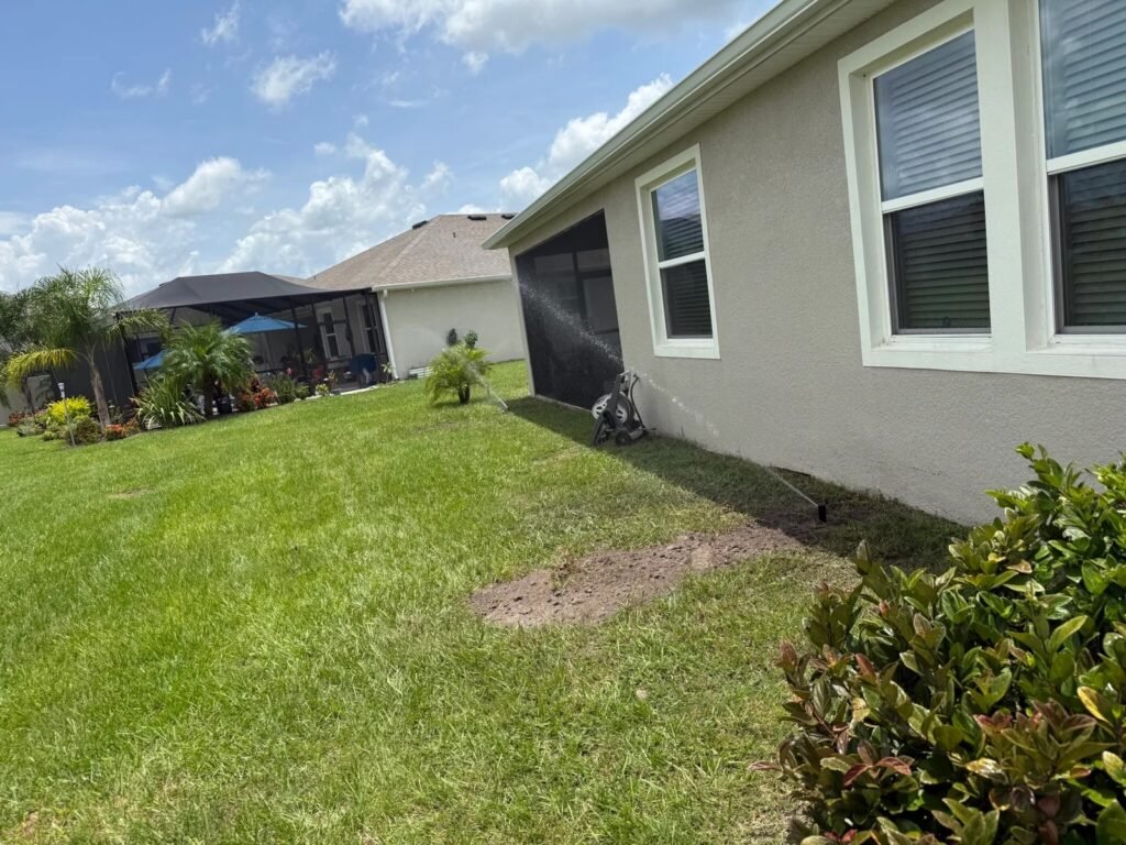 “Residential sprinkler irrigation system actively watering a lawn near the home, illustrating professional irrigation repair, system adjustment, and efficient lawn watering coverage in Ballantrae, FL