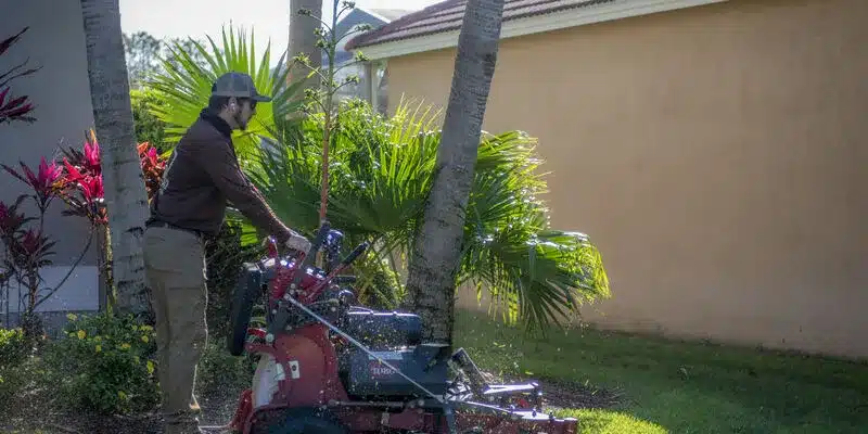 Landscaper maintaining lawn with equipment, ensuring reliable lawn care service in Lutz, FL.